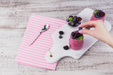 Berry güler yüzlü, sağlıklı Detoks yoğurt içki, diyet veya vegan gıda kavramı, taze vitaminler, ev yapımı Organik serinletici kokteyl kahvaltı için. Berry el tutar