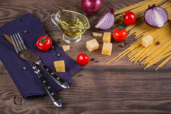 Ingredients for cooking spaghetti - raw pasta, tomato, olive oil — Stock Photo, Image