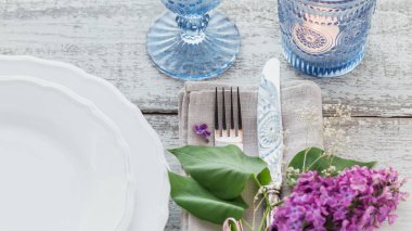 Rustik tablo ayarını hafif ahşap masa üzerinde Eflatun çiçekli. Tatil dekorasyon Provence stili. Romantik bir akşam yemeği.