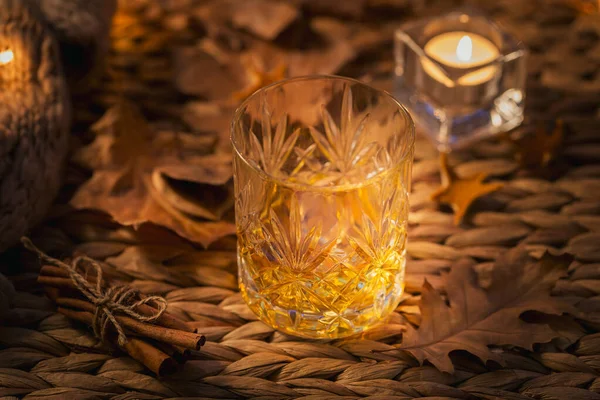 Whisky, konjak eller sprit, kryddor och höstdekorationer i mörker — Stockfoto