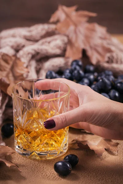 Um copo de uísque ou bourbon, especiarias e decoração em bac escuro — Fotografia de Stock