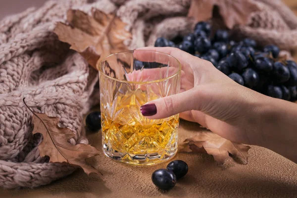 Whiskey, brandy ou licor, especiarias e decorações de outono no escuro — Fotografia de Stock