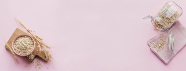 Bir kase kuru yulaf gevreği ve hafif arka planda buğday kulakları. Yulaf lapası pişirme konsepti. Üst görünüm