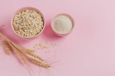 Bir kase kuru yulaf, yulaf ezmesi ve arka planda buğday. Sağlıklı gıda konsepti..