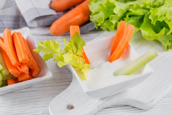 Healthy breakfast with yogurt, celery and carrot sticks. Diet and Healthy snack food.