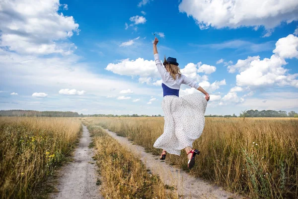 Genç romantik kadın yolun üzerinden alan üzerinde yüzer. Güzel bir bulutlu gökyüzü altında güzel doğanın keyfini kız. Arka iewv.