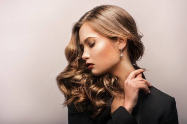 Güzel kahverengi saçlı güzel bir genç kadının portresi. Kız esmer mükemmel cilt üzerinde hafif bir arka plan ile. Reklam için boş alan.