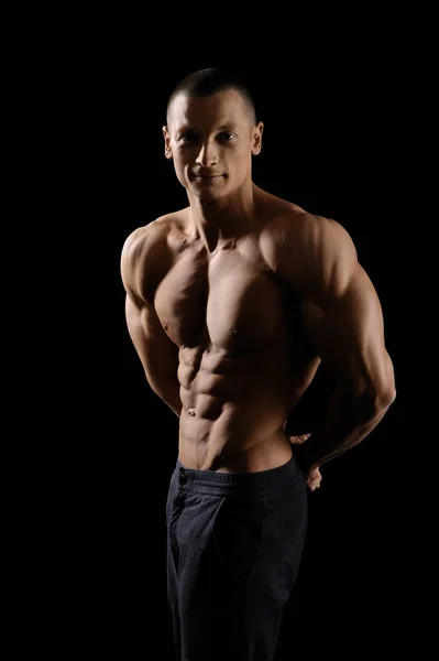 Mięśni fitness mężczyzna na czarnym tle — Zdjęcie stockowe