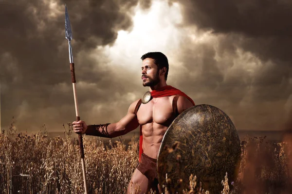 Warrior wearing like spartan holding iron weapon — Stock Photo, Image