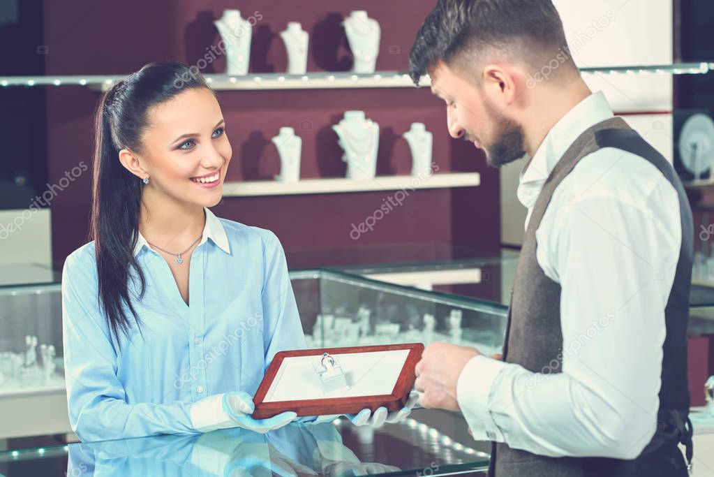 Handsome young man buying jewelry at the local jewelry store