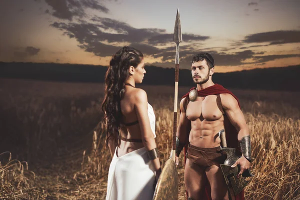 Woman like greece and man in armour meeting in field. — Stock Photo, Image