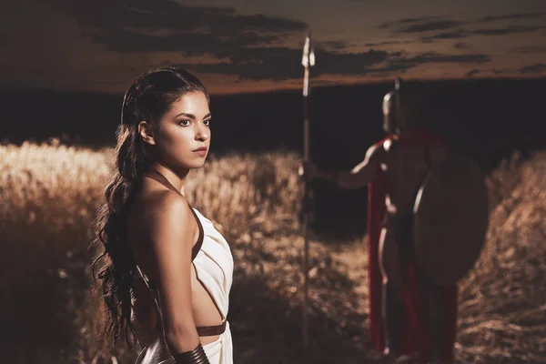 Kadın kask içinde adam karşı omuz üzerinden arıyor.