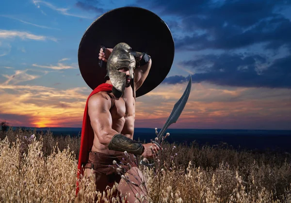 Warrior in helmet holding sword over head. — Stock Photo, Image