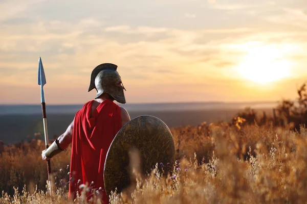 Inkognito-Krieger mit eisernem Helm und rotem Mantel. Stockfoto