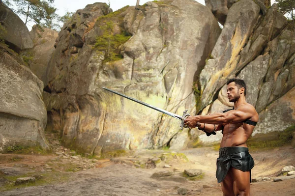 Jovem guerreiro forte com uma espada — Fotografia de Stock