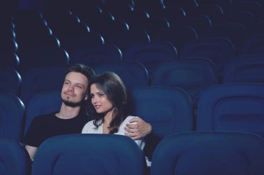Çift kucaklayan ve sinema halll tek başına oturmak.