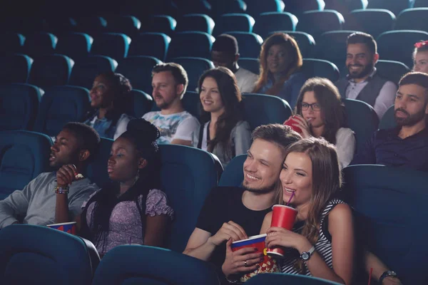 Casal sorridente bebendo cola e comendo pipoca no cinema . — Fotografia de Stock