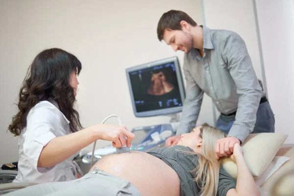 Любляча пара, яка відвідує лікаря для вагітності ультразвукова процедура — стокове фото