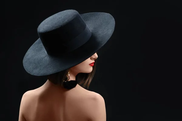 Привлекательная женщина в шляпе позирует на черном фоне — стоковое фото