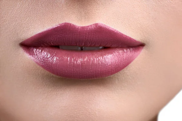 Primer plano de los labios de una mujer que usa lápiz labial o glo labial —  Fotos de Stock