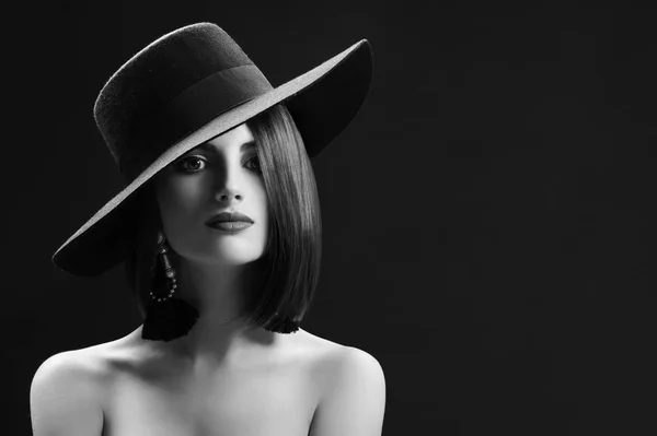 Ελκυστική γυναίκα που φοράει ένα καπέλο που παρουσιάζουν σε μαύρο φόντο — Φωτογραφία Αρχείου