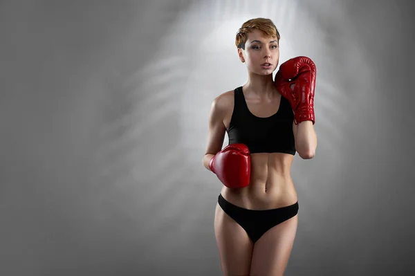 Noquea a la chica. Retrato de una joven y atractiva luchadora con guantes de boxeo posando —  Fotos de Stock