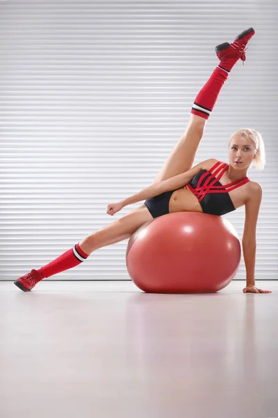 Jeune femme saine et sportive faisant de l'exercice sur le ballon de fitness au — Photo