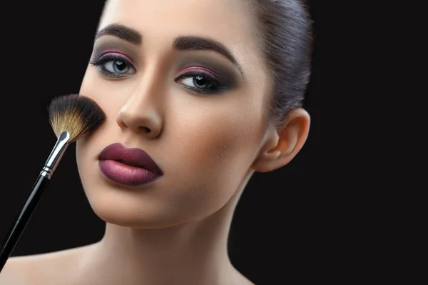 Joven hermosa mujer usando maquillaje profesional celebración de maquillaje —  Fotos de Stock