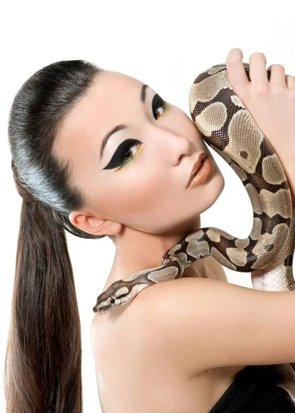 Beautiful Asian girl in a little black dress holding a snake — Stock Photo, Image