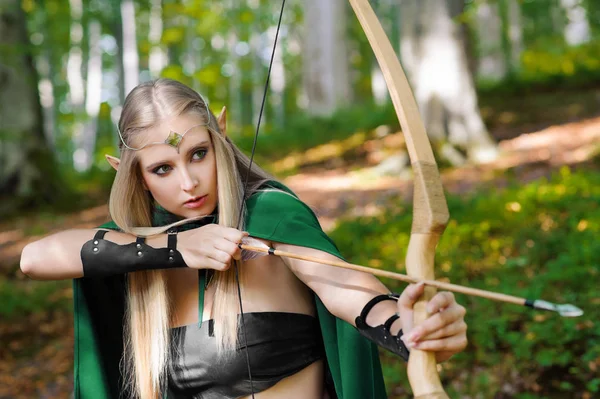 Bellissimo arciere elfo femmina nella foresta a caccia con un arco — Foto Stock
