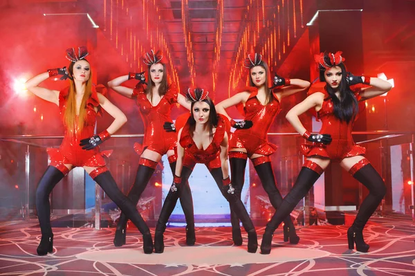 Group of sexy female dancers in red matching outfits performing