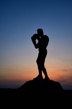 Açık havada Sunset'teki kaslı bir erkek boxer karanlık siluet