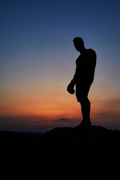 Ciemnej sylwetki mięśni męski bokser na zewnątrz na zachód słońca — Zdjęcie stockowe
