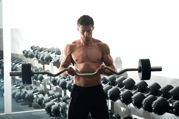 Unga fitness man med muskulös kropp tränar med ez lockig bomma — Stockfoto
