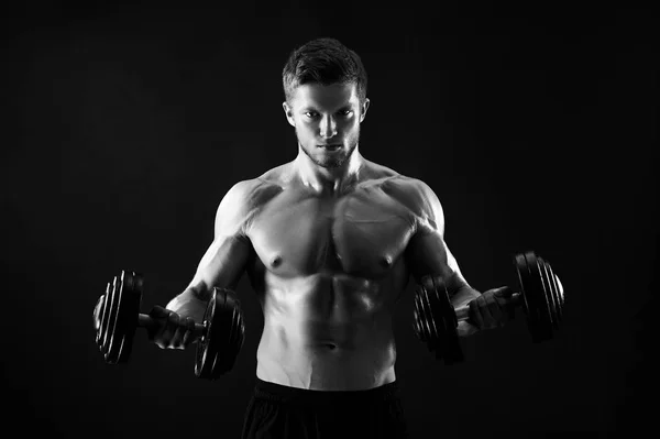 Monochrome shot of an athletic ripped young sportsman with dumbb — Stock Photo, Image