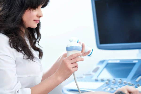 Krásný ženský lékař sedí ve své kanceláři poblíž ultrazvuk sc — Stock fotografie
