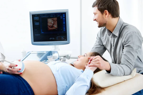 Jovem amando casal grávida visitando médico juntos — Fotografia de Stock