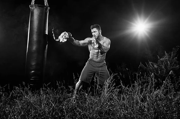 Profi-Boxer boxt Sandsack im Freien mit seinem Boxglo — Stockfoto