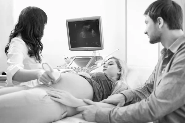 A fiatal terhes szerető pár látogató orvos együtt fekete-fehér — Stock Fotó