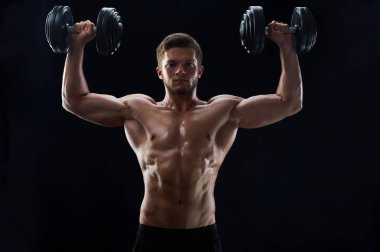 siyah arka plan üzerine ağırlık kas genç adam