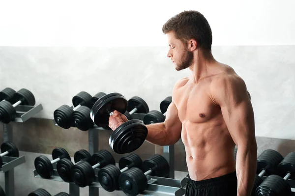 Handsome young athlete working out at the gym — Stock Photo, Image