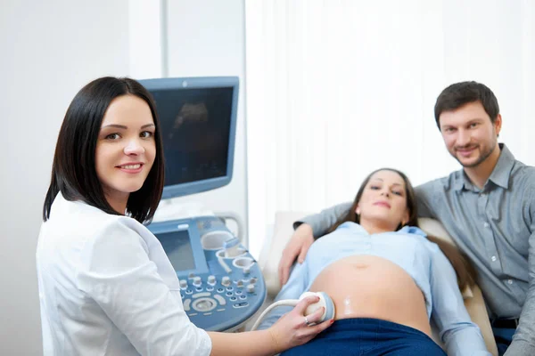 Jeune couple enceinte aimant médecin visiteur ensemble — Photo