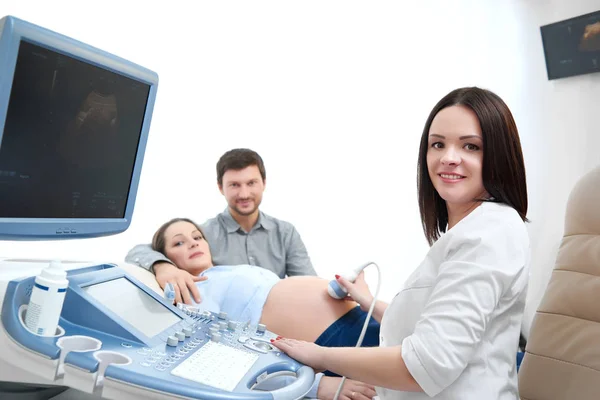 Jovem amando casal grávida visitando médico juntos — Fotografia de Stock