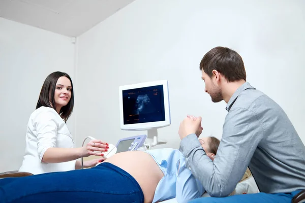 Jovem amando casal grávida visitando médico juntos — Fotografia de Stock