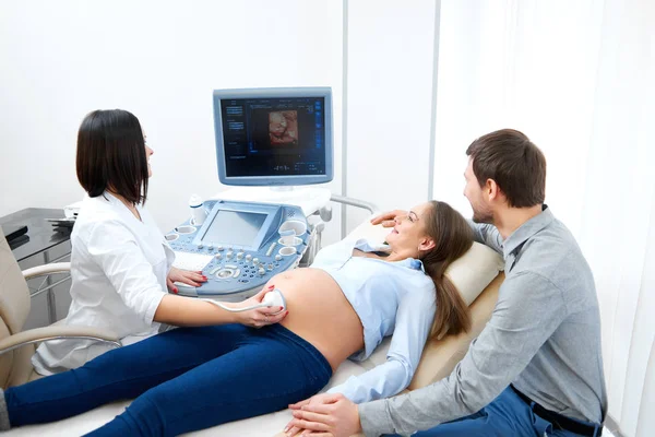 Jovem amando casal grávida visitando médico juntos — Fotografia de Stock