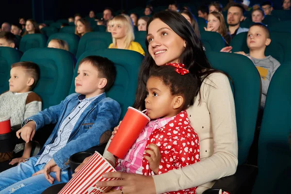 Niños con padres disfrutando de una película juntos en el cine — Foto de Stock