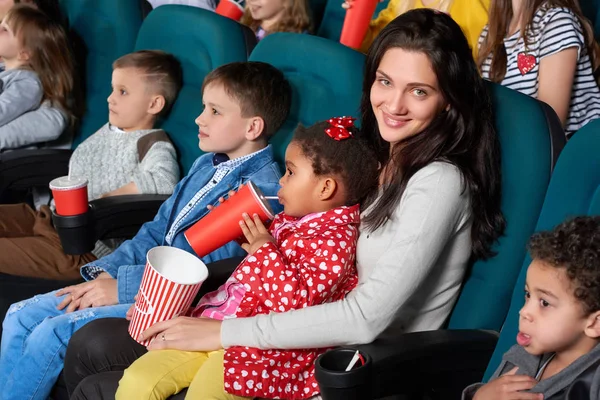 Dzieci z rodzicami, ciesząc się film razem w kinie — Zdjęcie stockowe