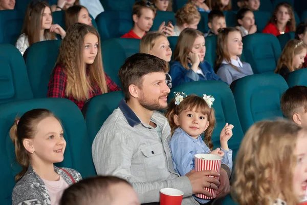 映画館で一緒に映画を楽しんでいる親を持つ子供 — ストック写真