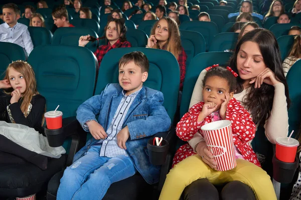 Дети с родителями, наслаждающиеся совместным кино в кинотеатре — стоковое фото