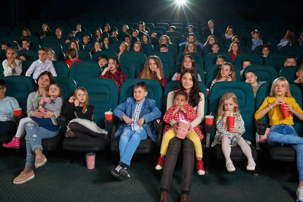 Children with parents enjoying a movie together at the cinema — Stock Photo, Image